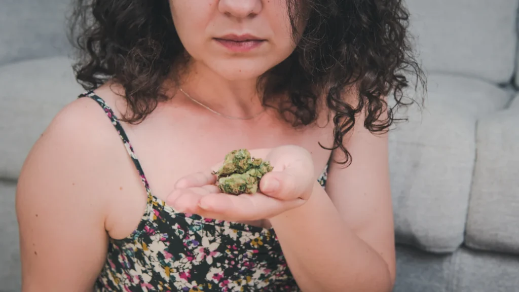 Woman holding cannabis buds, representing natural relief and alternative treatment using cannabis for nerve pain.