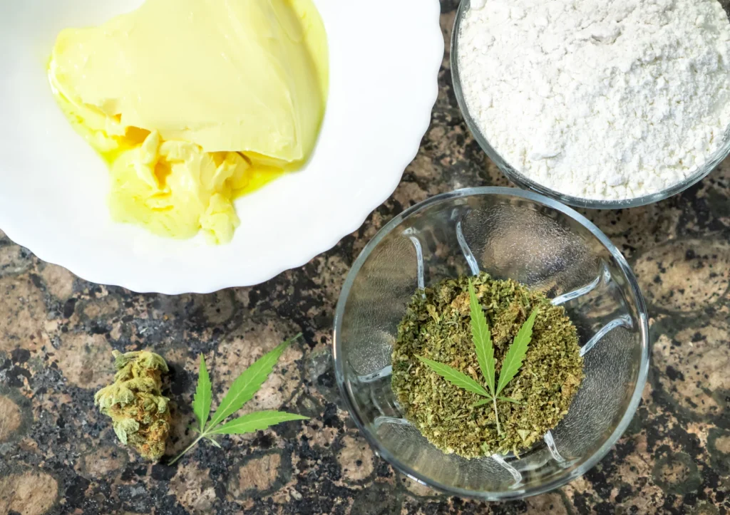 Cooking with cannabis concept showing butter, flour, and ground cannabis ingredients prepared on a kitchen counter for making edibles.