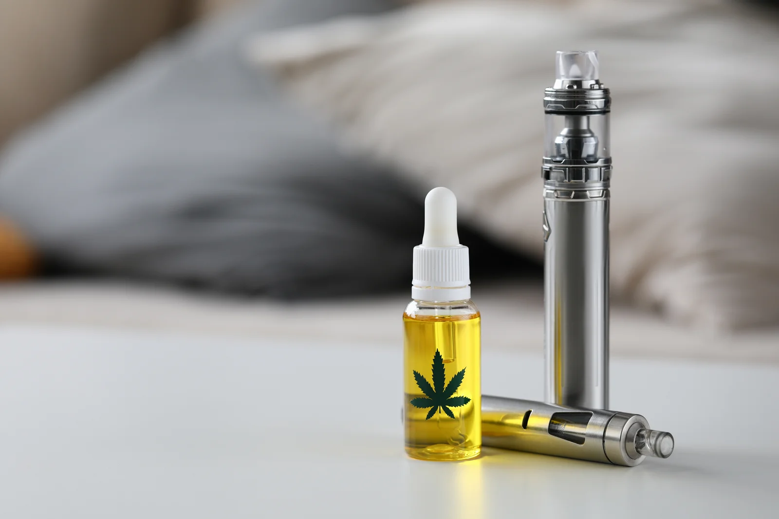 Cannabis vaporization setup with vape pens and a bottle of cannabis oil, representing safe and efficient methods of consuming cannabis through vaporization.