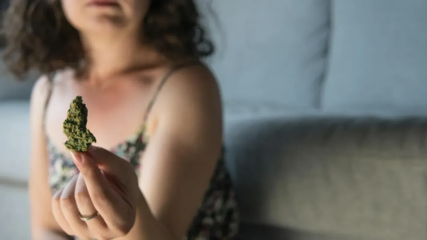 Woman holding cannabis bud close-up